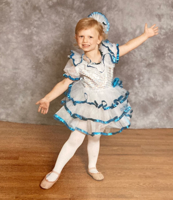 Arianna as a toddler in a tutu posing for her dance photos.